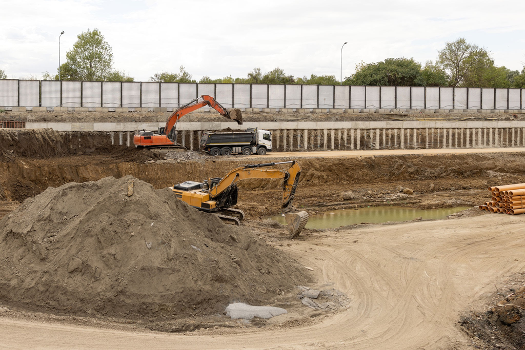 Heavy machinery clearing and grading soil for a foundation